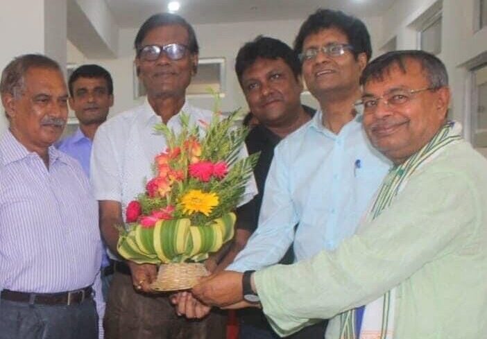 Faculty welcoming a distinguished visitor with a bouquet