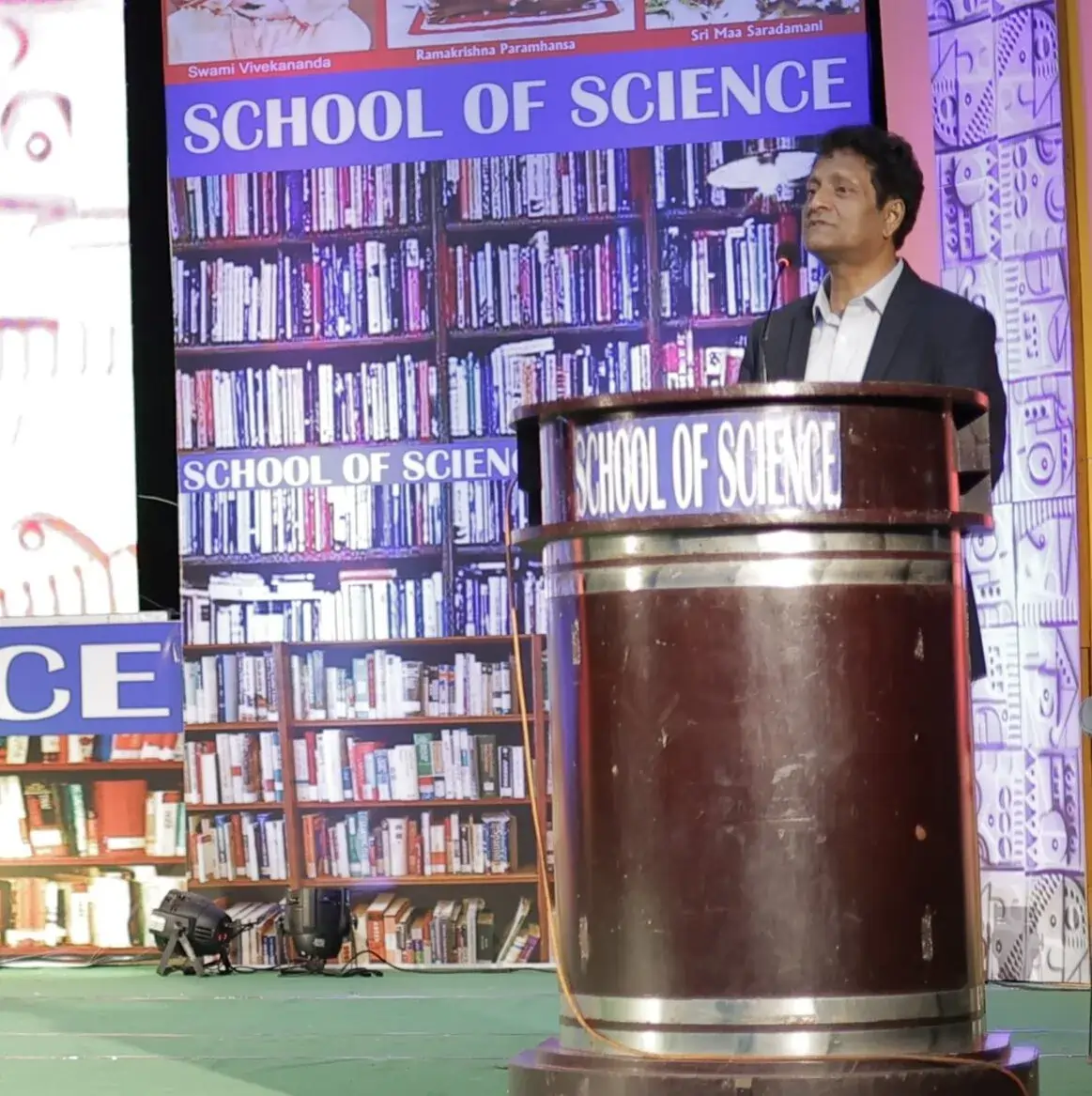 A School of Science mentor addressing students at a podium