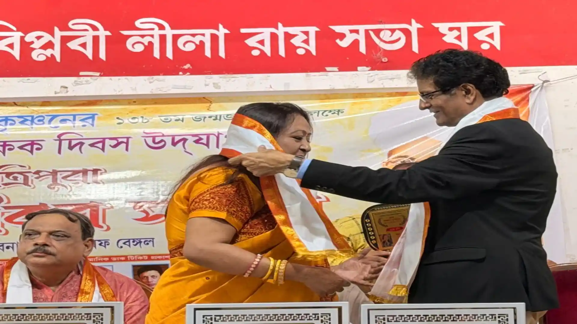 Abhijit Bhattacharjee felicitating a teacher with shawl and award