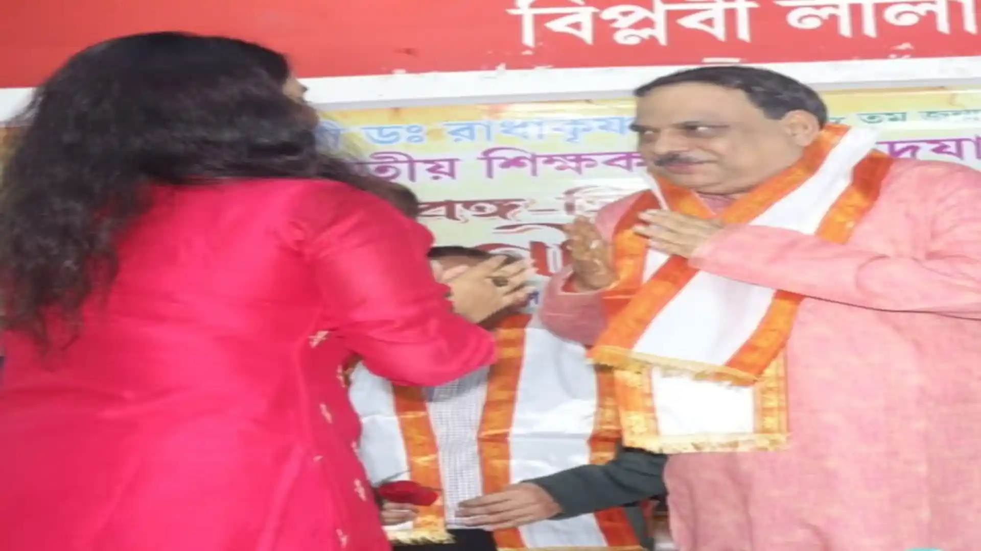 Teacher receiving shawl and felicitation on stage